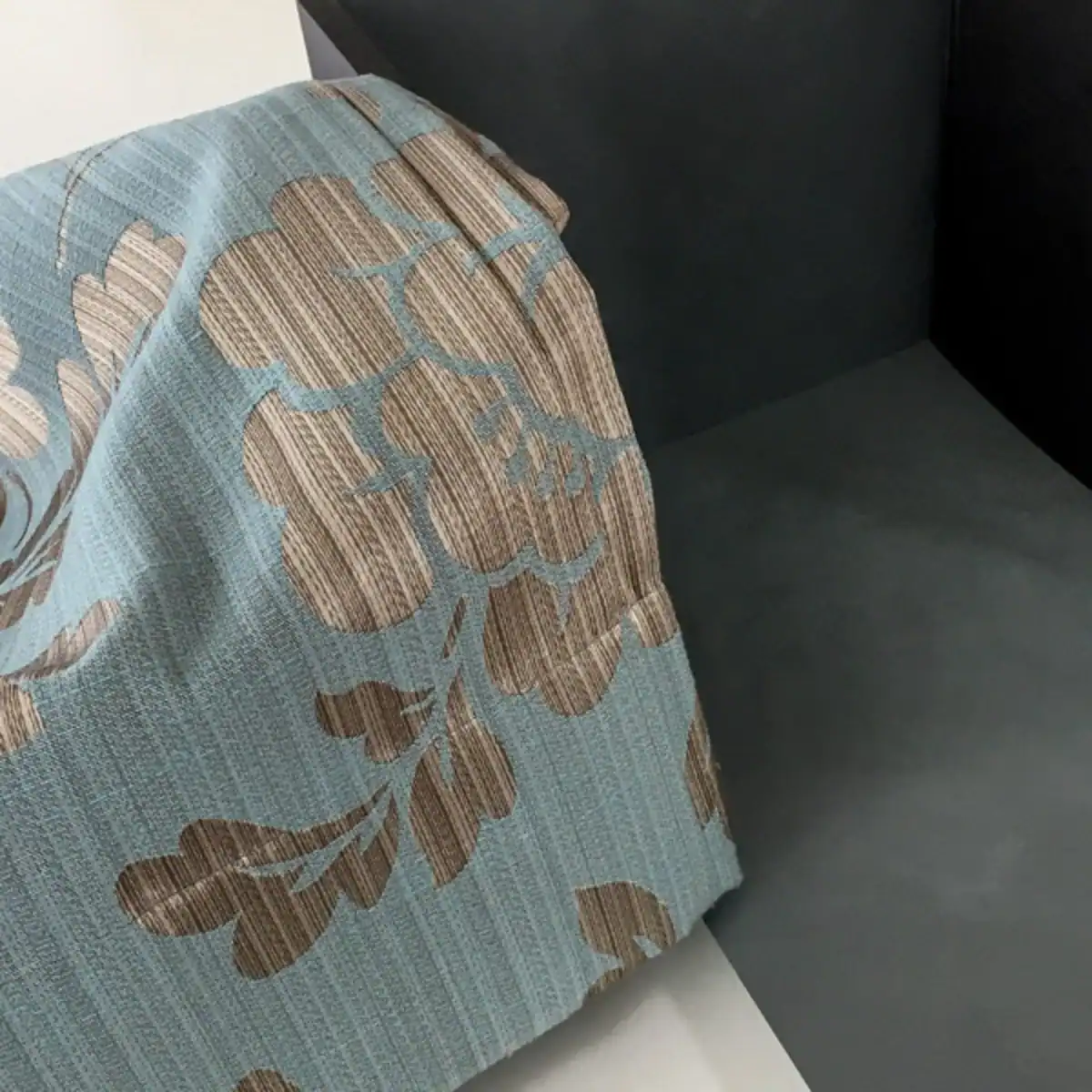 Bemusterung für eine Farbgestaltung: Zusammenspiel von einem dunklen Farbmuster in Rauchblau für die Wand und einem blauen Vorhang mit Silberornamenten.