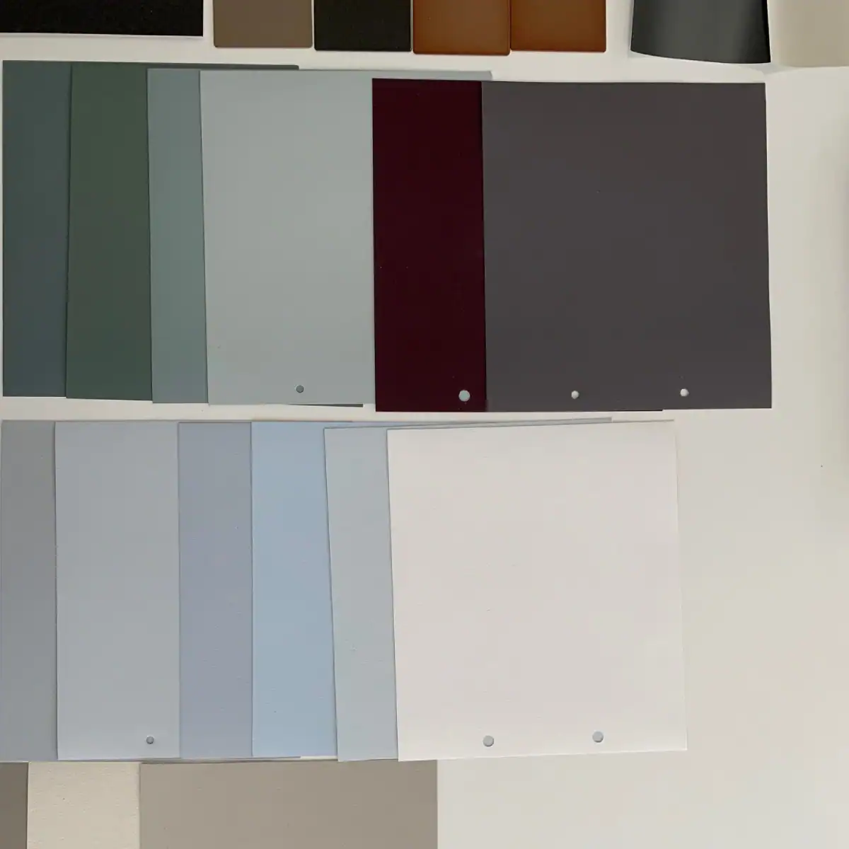 Farbgestaltung Home-Office: Konzeptentwicklung. Eine Zusammenstellung von grossen Farbmusterblättern in Reihen: Oben dunkle graublaue, grünliche und Anttrazit-Töne. Unten helle Farbnuancen von Weiss, Grau, Blau und Umbra.