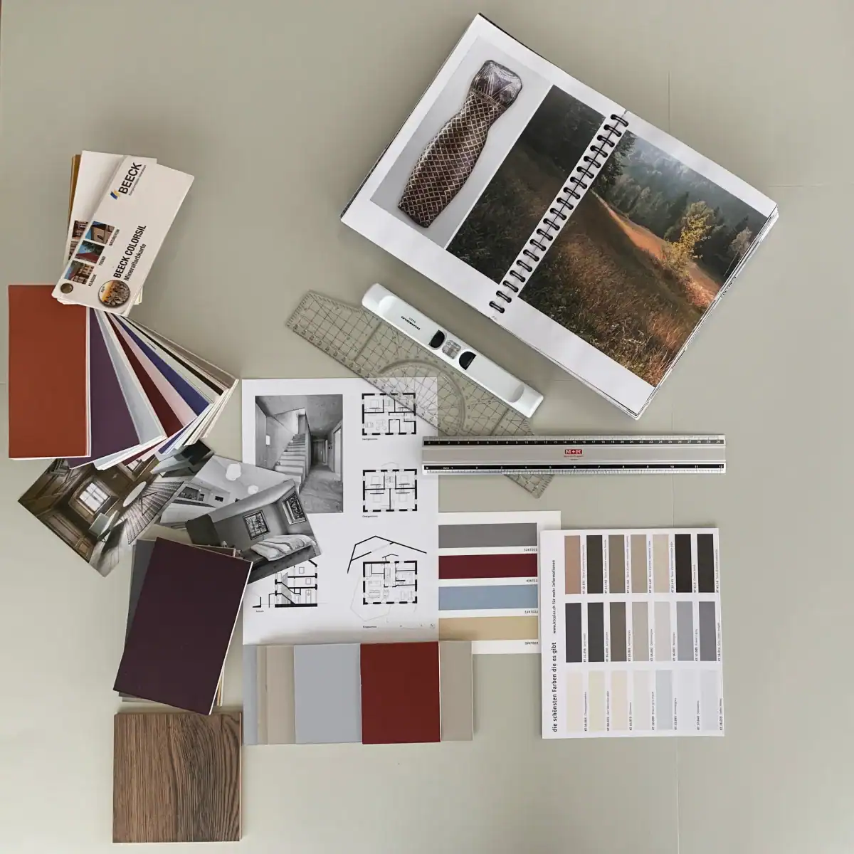 Konzeptarbeit für die Farb- und Materialgestaltung: Eine Auslegeordnung mit Farbfächern, verschiedensten Farbmustern, Grundrissplänen, Inspirationsbildern und Arbeitsmaterialien.