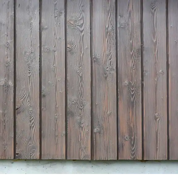Detail der Treppenhausgestaltung im Einfamilienhaus aus den 50er-Jahren. Schräge Sicht nach oben ins Obergeschoss. Links Akzentwand in Rot, die vom Eingang bis ins Obergeschoss leitet, übrige Wände in abgetöntem Weiss. Treppentritte in hellbeigen Steinplatten, Betonunterteil in abgetöntem Weiss, schwarze Metallbrüstung. An der Rückwand ein quadratisches Bild mit kreisförmigem Motiv in Weiss, Orange und Blau auf tiefdunklem rotviolettem Hintergrund. Klare, reduzierte Architektursprache, die aus den Kontrasten lebt.