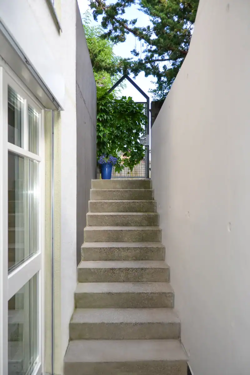 Bemusterung für eine Farbgestaltung: Zusammenspiel von einem dunklen Farbmuster in Rauchblau für die Wand und einem blauen Vorhang mit Silberornamenten.