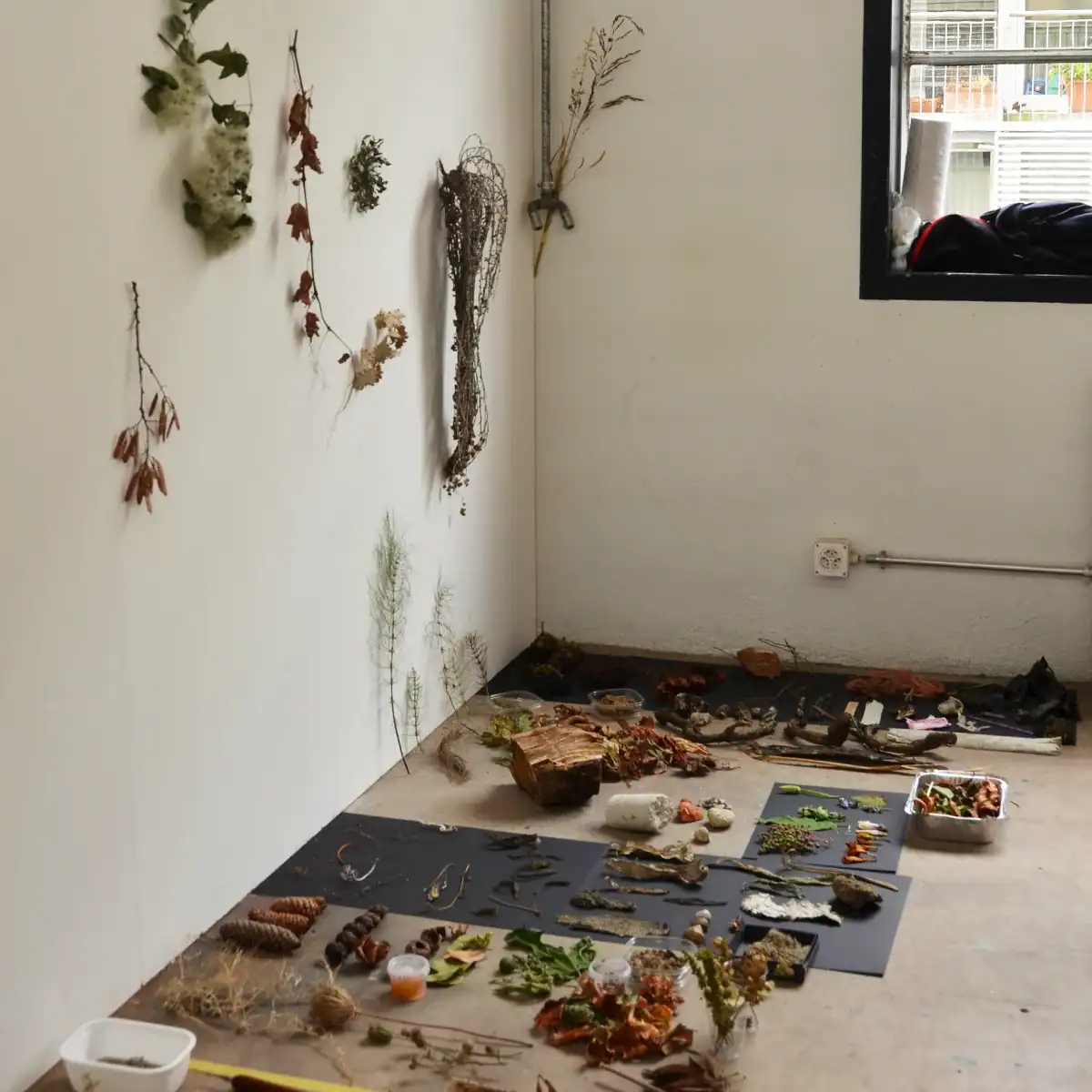 Studio für Yoga und Pilates. Farbkonzept für die neue Wandgestaltung mit verschiedenen Farb- und Materialmustern der bestehenden Elemente (Boden, Wandfarben und Holzelemente) sowie den Werbepostkarten des Studios, deren Farbigkeit in Gelborange, Rotbraun, Weiss, Grau und Anthrazit in die neue Farbgestaltung aufgenommen werden soll. Die Postkarten zeigen verschiedene Yoga- und Pilatesübungspositionen von männlichen und weiblichen Personen. Drei quadratische Farbmuster in Echtmaterial zeigen den entwickelten Farbklang Wollweiss, Goldocker und Mauveanthrazit.