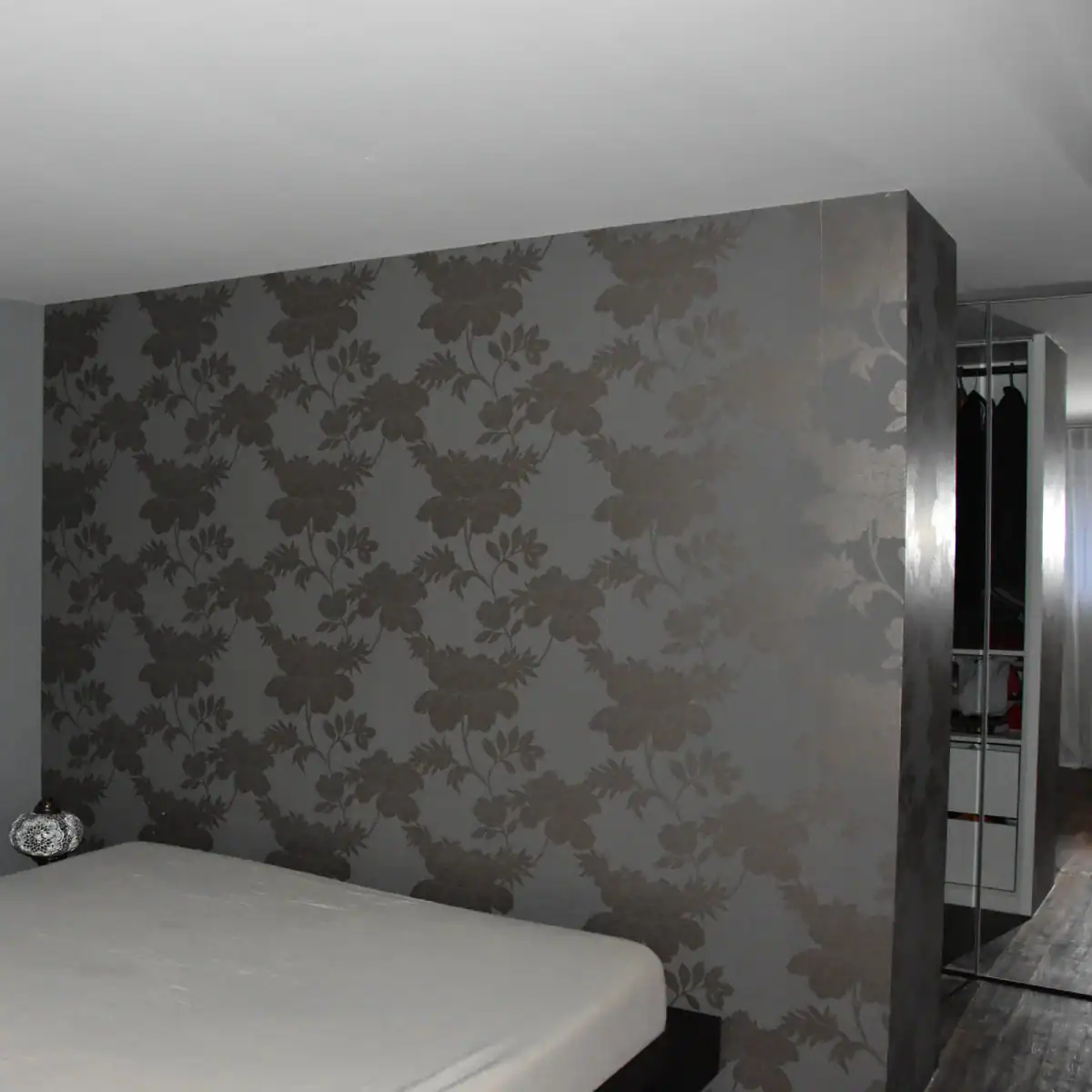 Studio für Yoga und Pilates. Personal-Trainingsraum. Blick von der Nordwand Richtung Akzentwand in Mauveanthrazit. Linke Wand zum Gruppentrainingsraum in Weiss, Tür hellgrau. Rechts Westwand in Weiss mit grossen Fenstern. Mitteldunkler honigfarbener Laminatboden und helle Holzdecke. Im Raum stehen verschiedene Pilates-Trainingsgeräte in hellem Holz und mit mittelgrauen gepolsterten Liege- und Sitzflächen. Die Anthrazitwand gibt dem Raum Halt und klare Orientierung.